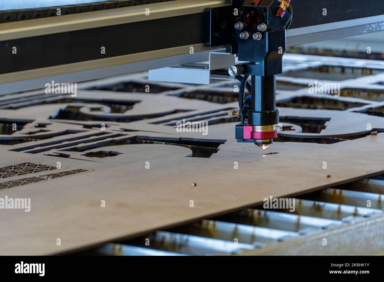 Laserschneidemaschine, Schneiden von Holzplatten, während ein Mann zeichnet den Prozess, mexiko Stockfoto