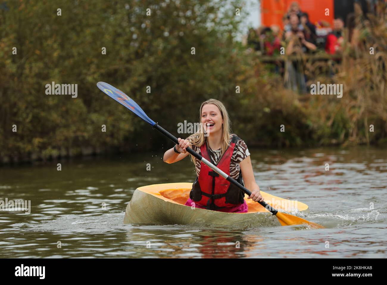 Kasterlee, Belgien. 23. Oktober 2022. Eine Frau tritt bei der Kürbisregatta im Dorf Lichtaart in Kasterlee, Belgien, am 23. Oktober 2022 an. Die Kürbis-Regatta 13. ist ein Kajakwettbewerb in Belgien, der Teilnehmer dazu anzieht, in großen ausgehöhlten Kürbissen zu sitzen und zu konkurrieren. Nach Angaben der lokalen Organisatoren könnte das Gewicht jedes Kürbisses, der in ein Boot verwandelt wurde, Hunderte von Kilogramm erreichen. Quelle: Zheng Huansong/Xinhua/Alamy Live News Stockfoto