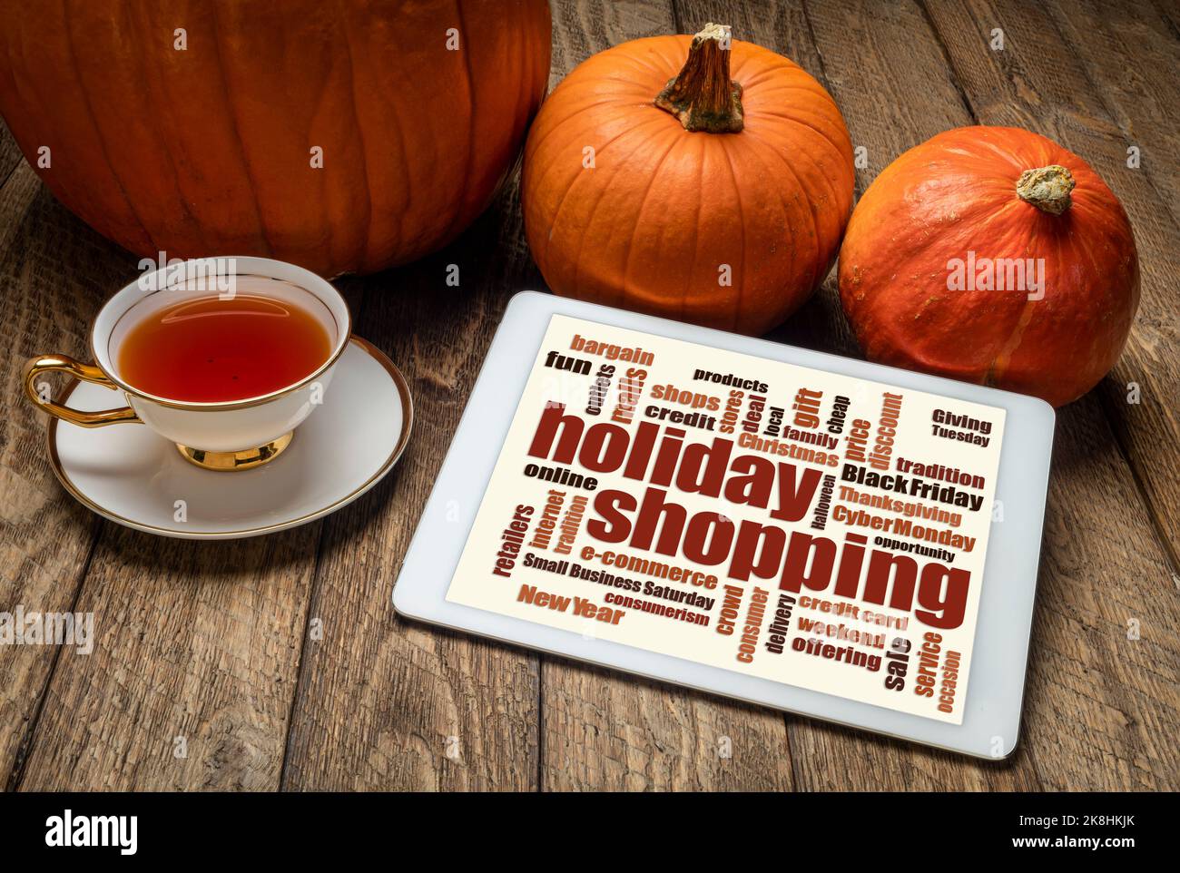 Holiday Shopping Wortwolke auf einem digitalen Tablet mit Kürbissen und einer Tasse Tee Stockfoto