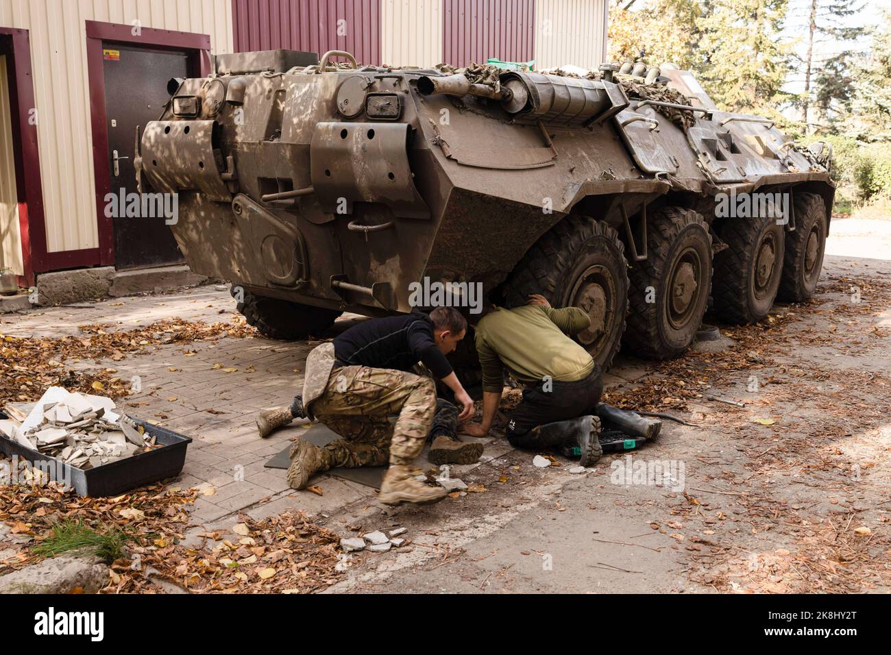 Bakhmut, Ukraine. 19. Oktober 2022. Ukrainische Soldaten wechseln die Reifen auf einem APC, einem gepanzerten persönlichen Träger der ukrainischen Armee in der Nähe eines beschädigten Gebäudes nach einem russischen Beschuss in der Stadt Bakhmut. Bakhmut ist eine der am schlimmsten beschossen Städte an den Fronten des Donbass-Krieges, seit Russland am 24. Februar 2022 seine umfassende Invasion in der Ukraine startete. (Bild: © Jan Husar/SOPA Images via ZUMA Press Wire) Stockfoto