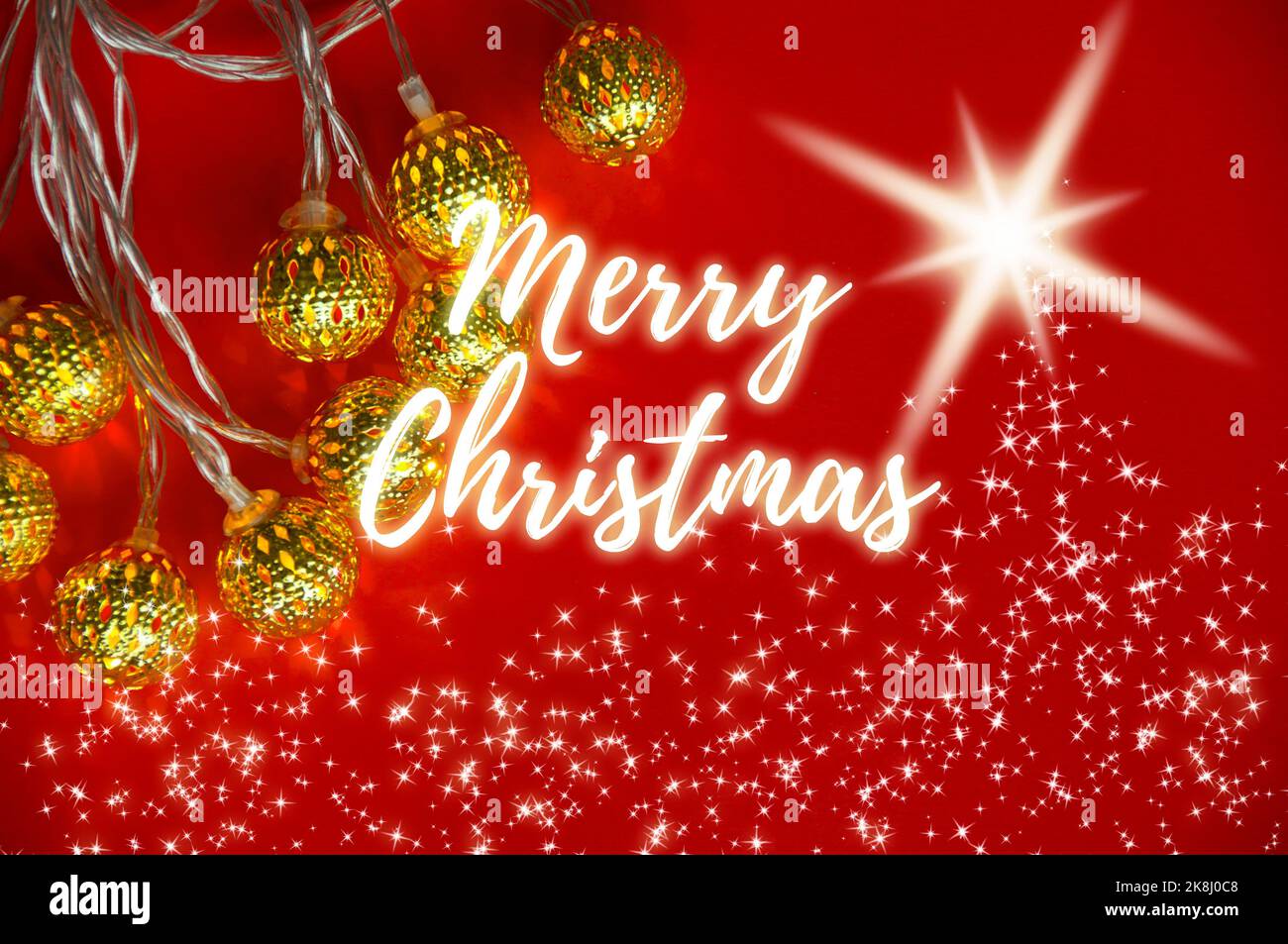 Frohe Weihnachten wünscht Text mit Weihnachtsdekoration und leuchtenden Sternen und goldenen Kugeln auf rotem Hintergrund. Weihnachtsfeier Konzept. Stockfoto