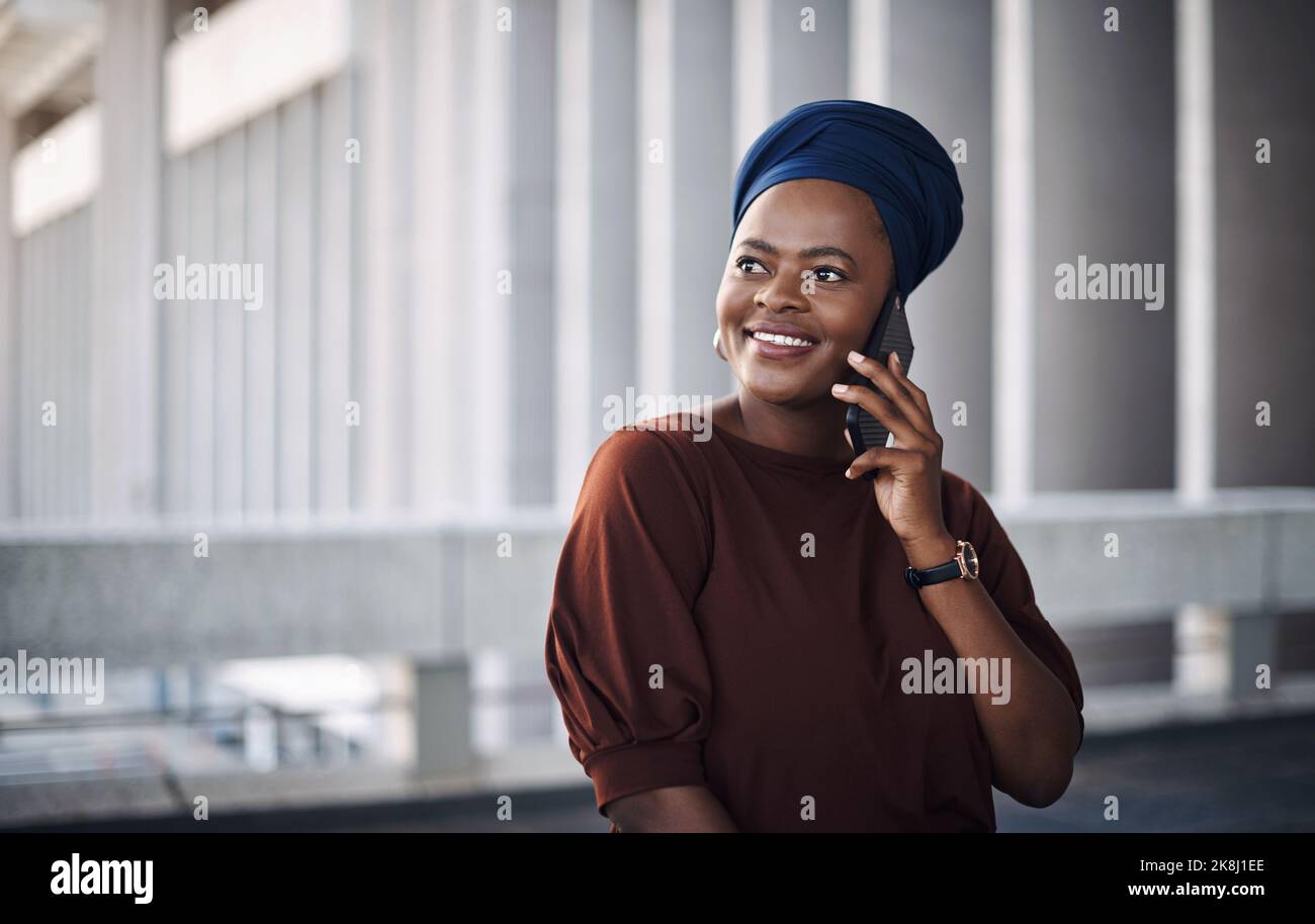 Bleiben Sie in Verbindung, bleiben Sie in Kontakt. Eine junge Geschäftsfrau, die ein Smartphone vor dem Hintergrund einer Stadt nutzt. Stockfoto