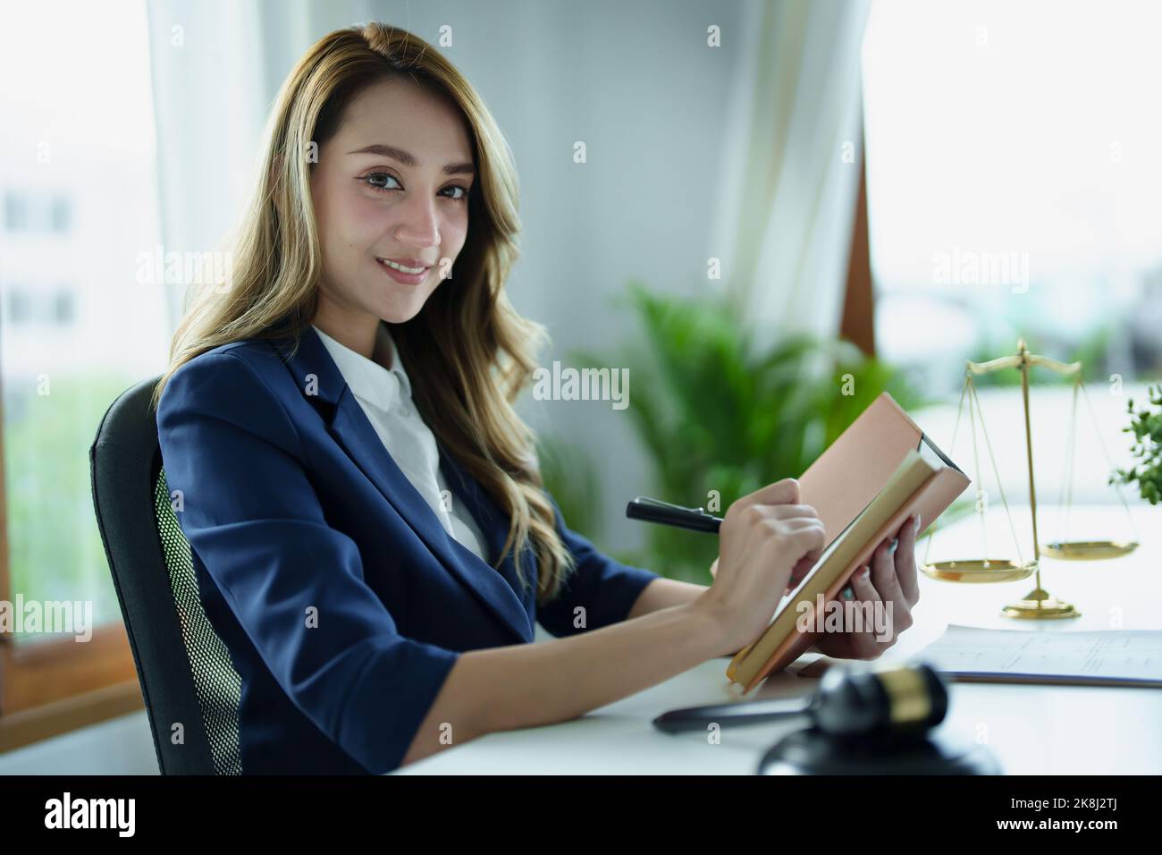 Porträt eines jungen asiatischen Rechtsanwalts, der eine Klage für einen Kunden studiert und dabei Notebooks und Papierkram auf einem Schreibtisch verwendet Stockfoto