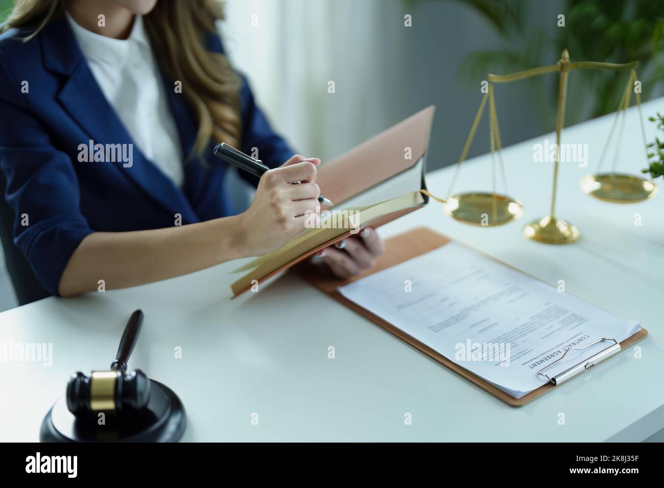 Porträt eines jungen asiatischen Rechtsanwalts, der eine Klage für einen Kunden studiert und dabei Notebooks und Papierkram auf einem Schreibtisch verwendet Stockfoto