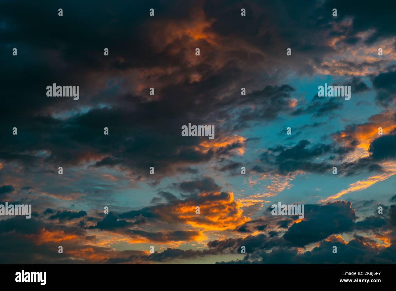 Dramatische Wolken bei Sonnenaufgang. Filmische Kulisse oder Hintergrundfoto mit bewölktem Himmel. Bei Sonnenaufgang oder Sonnenuntergang ist der Himmel teilweise bewölkt. Stockfoto