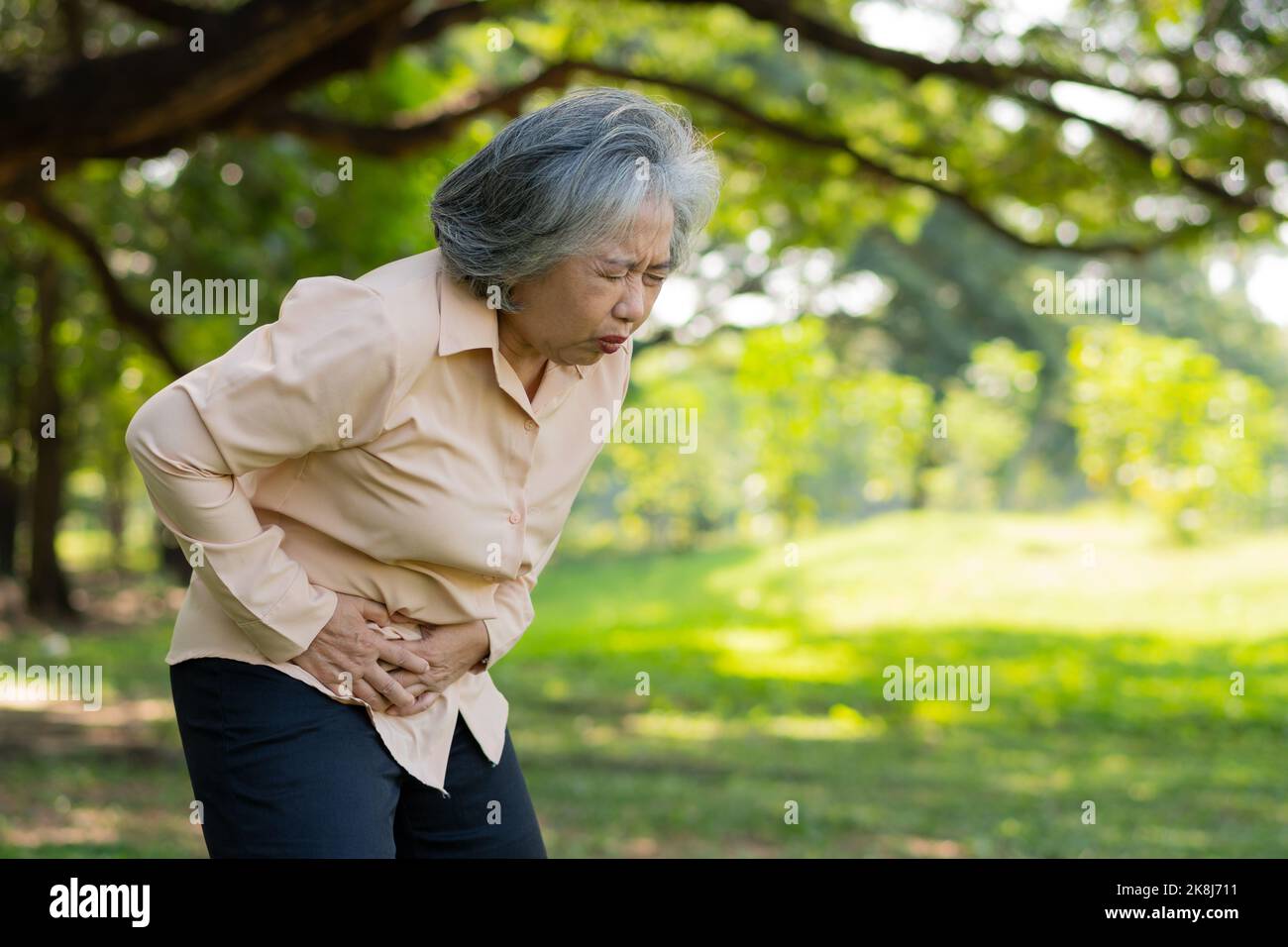 Kranke asiatische ältere Frau Magenschmerzen oder Gastroenterologen, ältere Menschen haben ein Magenproblem, akute Pankreatitis verursachen Magenschmerzen, Symptome Gastroint Stockfoto