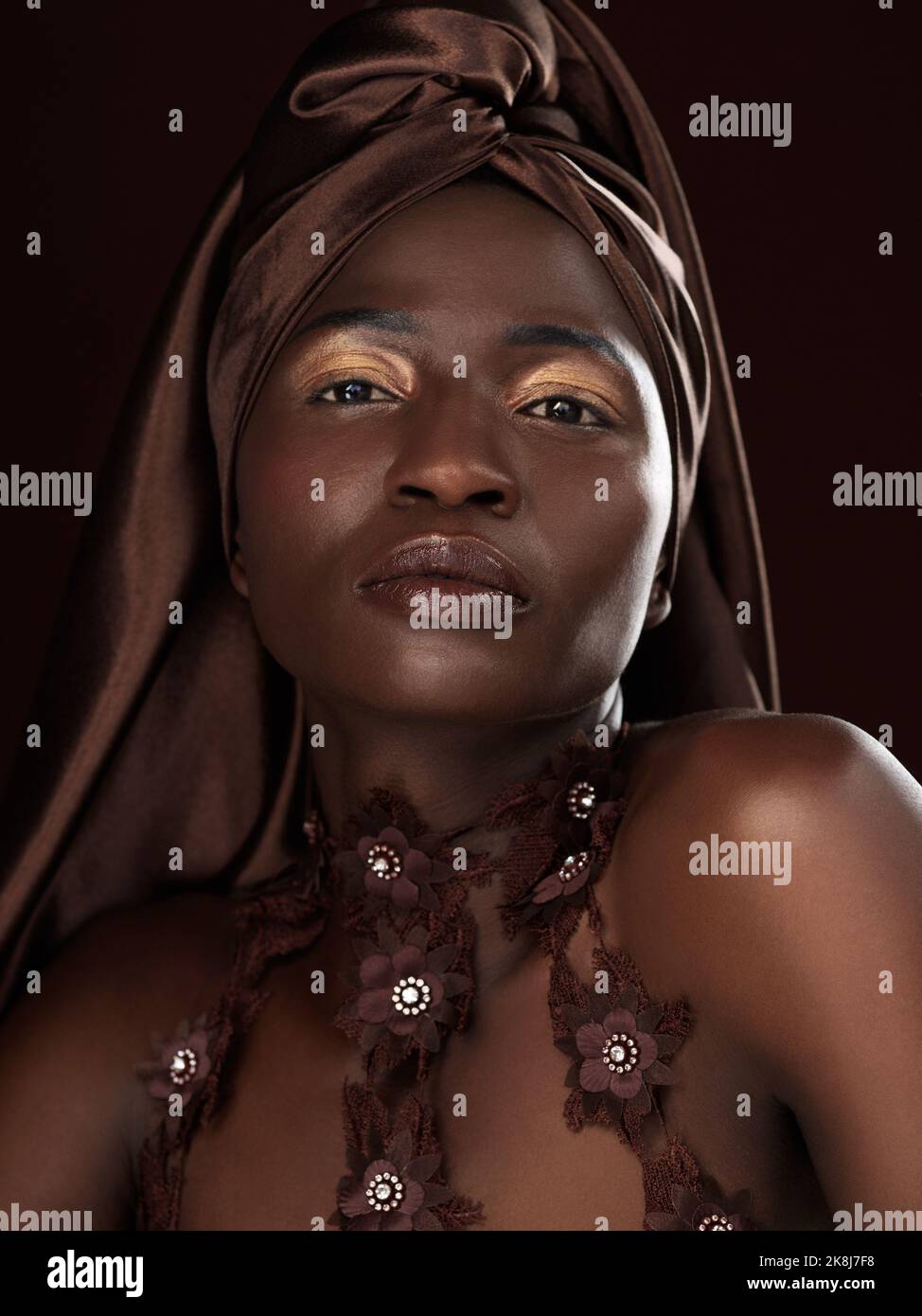 Packen Sie sich ein wie das Geschenk, das Sie sind. Studioporträt einer attraktiven jungen Frau, die in traditioneller afrikanischer Kleidung vor schwarzem Hintergrund posiert. Stockfoto