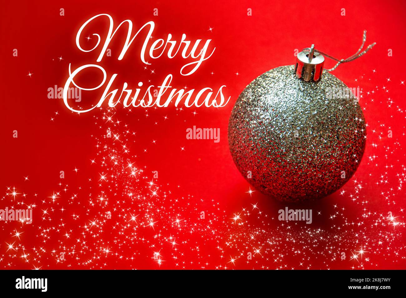 Frohe Weihnachtswünsche mit silberner Kugel und leuchtenden Sternen auf rotem Hintergrund. Weihnachtsfeier Konzept. Stockfoto