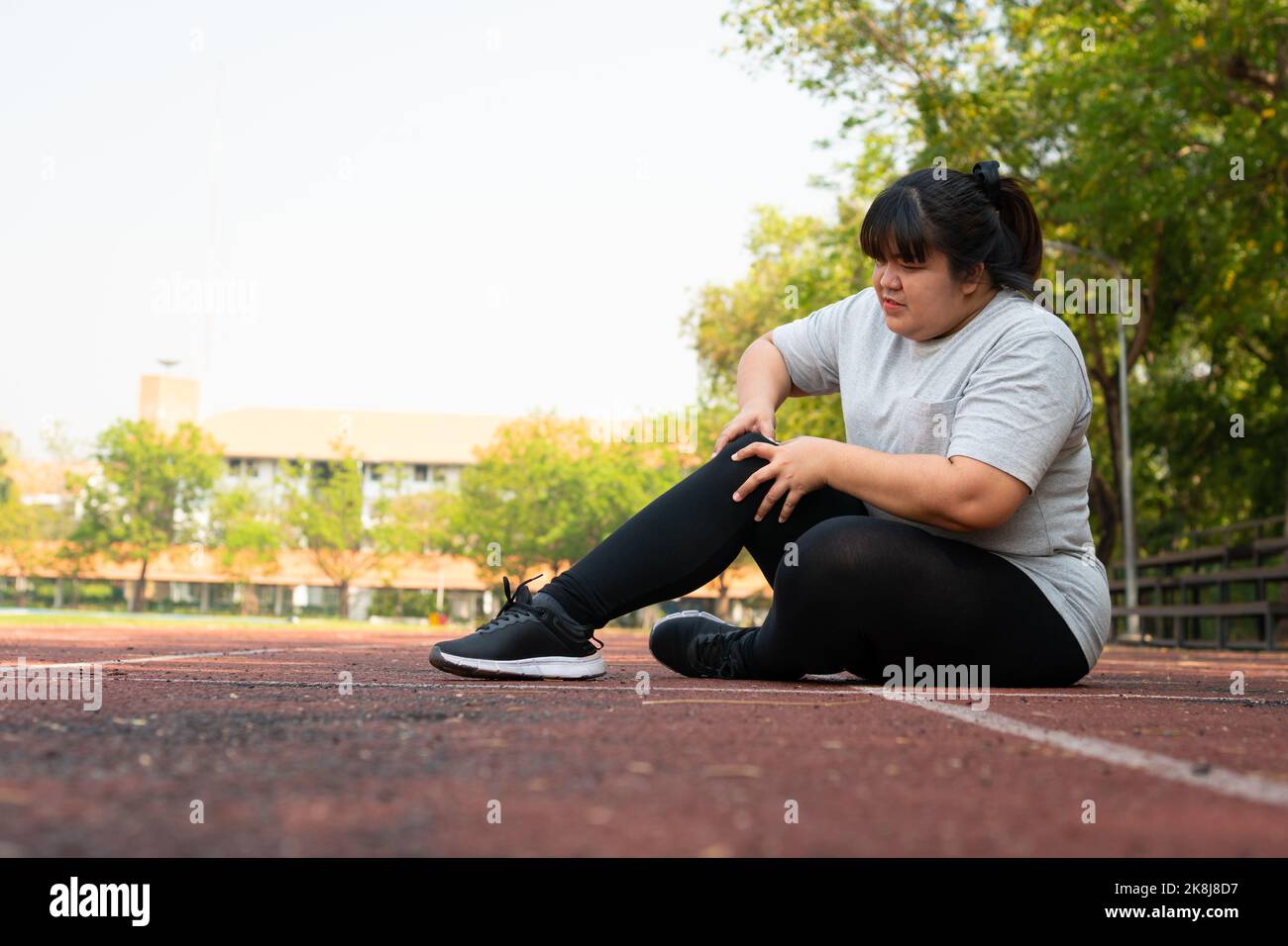 Asiatische übergewichtige Frau eine neue Läuferin Schmerzen Knöchel beim Laufen, Athlete Läufer Trainingsunfall. Sport Laufen Knöchel verstauchte Verstauchung verursachen Verletzungen. wei Stockfoto