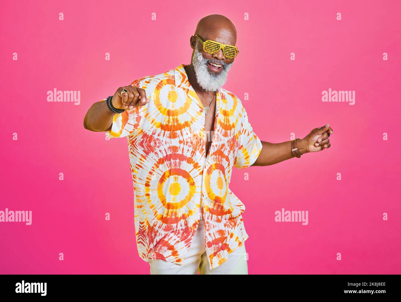 Hes immer noch hip und happening. Ein flippiger und stilvoller Senior, der im Studio vor rosafarbenem Hintergrund tanzt. Stockfoto