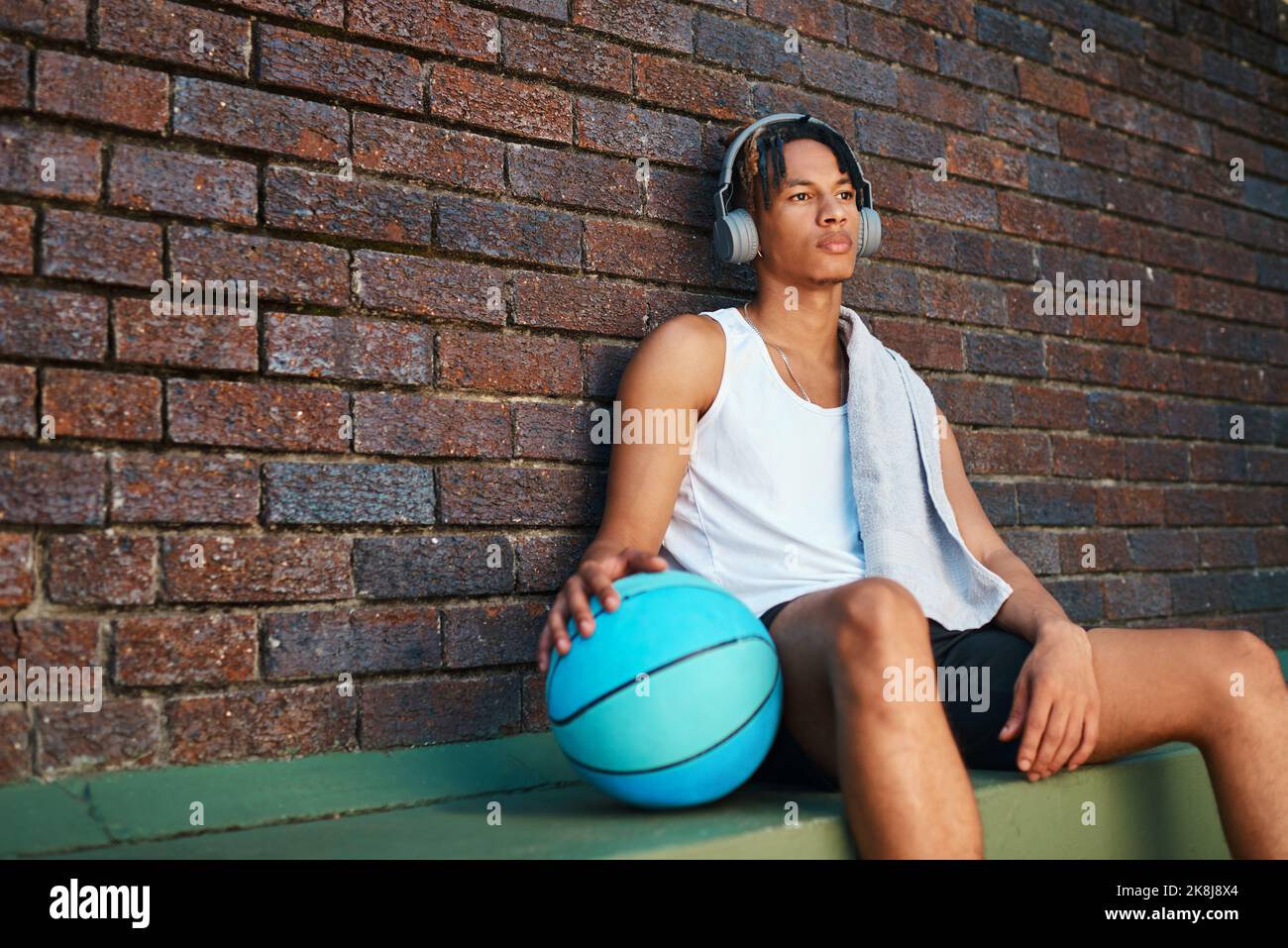 Ein Tag ohne Basketball ist ein Tag, der verschwendet wird. Ein sportlicher junger Mann, der nach einem Basketballspiel eine Pause macht. Stockfoto