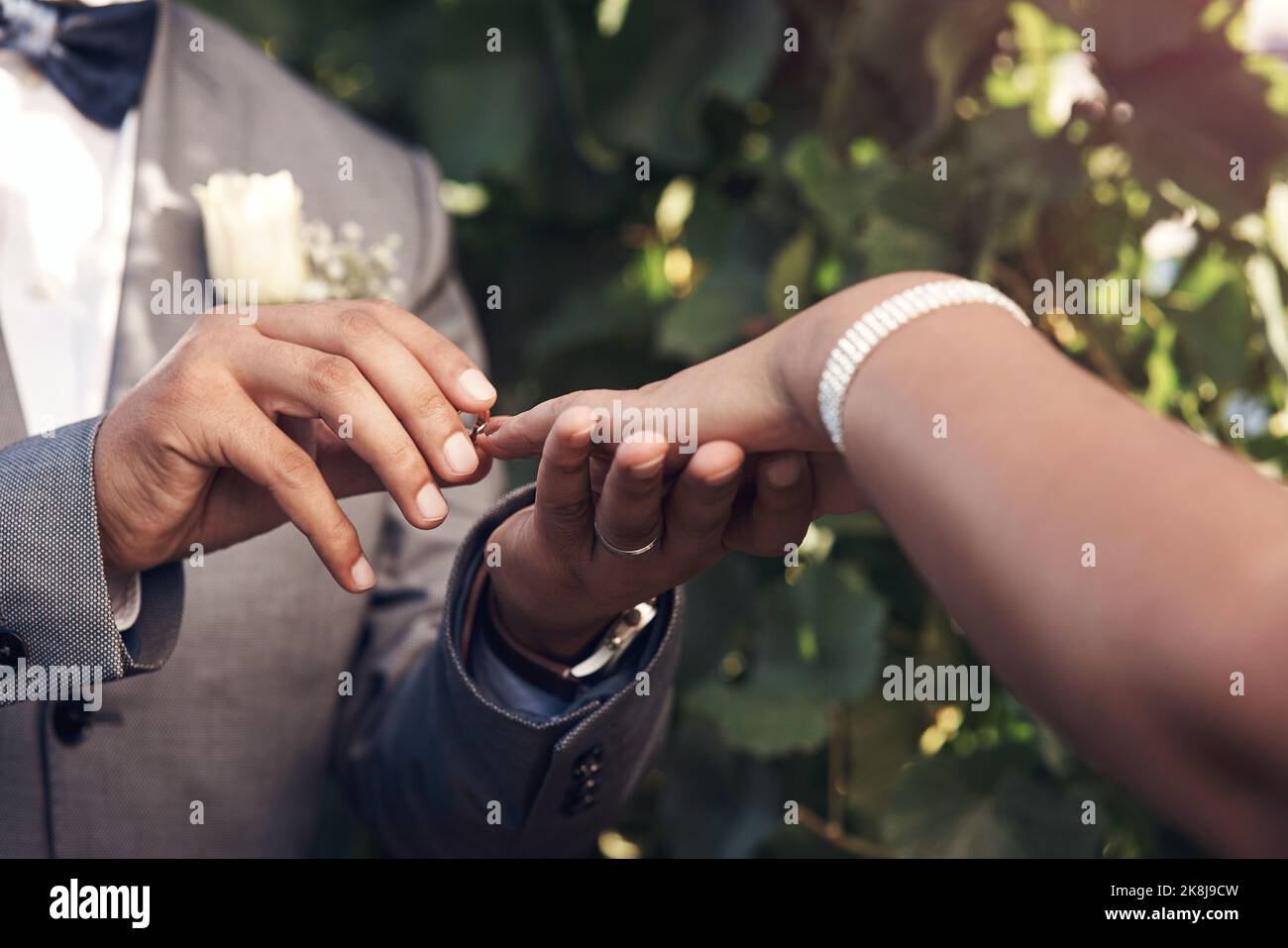 Dieser Ring ist ein Zeichen meiner Liebe zu Euch. Ein unverkennbares Paar tauscht während der Hochzeitszeremonie Ringe aus. Stockfoto