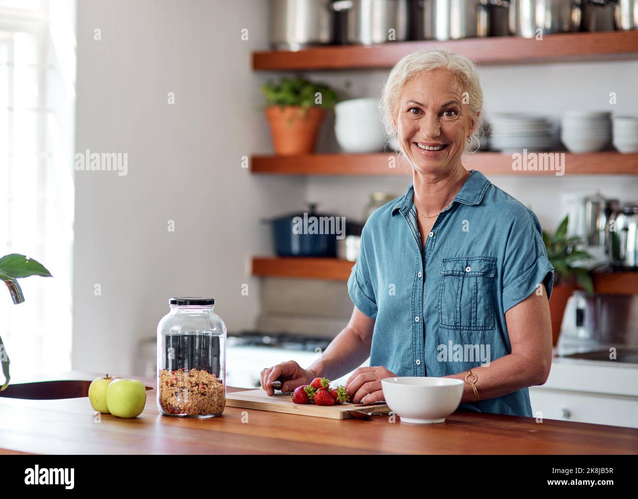 Anti-Aging beginnt in der Küche. Porträt einer reifen Frau, die in der Küche zu Hause ein gesundes Frühstück zubereitet. Stockfoto