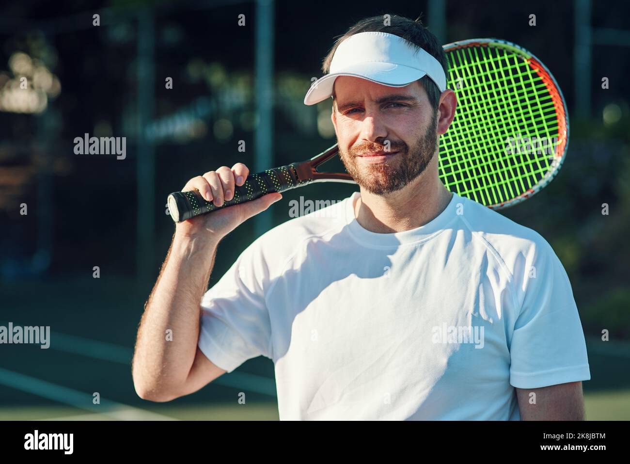 Ich lasse meinen Schläger reden. Porträt eines sportlichen jungen Mannes, der mit einem Tennisschläger auf einem Tennisplatz steht. Stockfoto