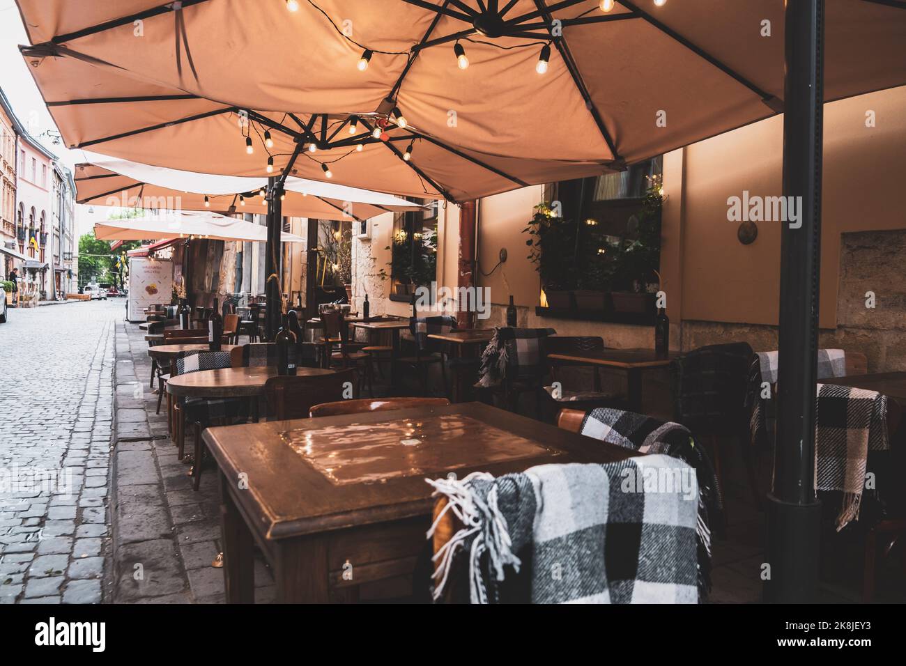 Verbringen Sie Zeit auf der Terrasse: Gemütliches Straßencafé mit hölzernen Korbstühlen und blühenden Hortensien. Garten oder Datscha Restaurant außerhalb der Stadt. Stilvoller pa Stockfoto