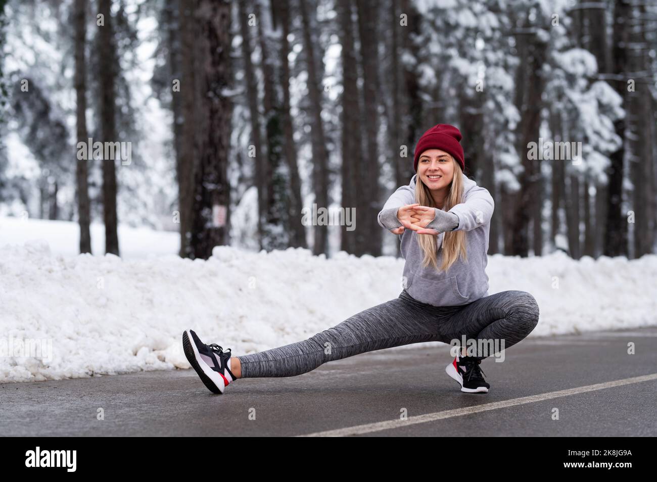 Schöne junge sport Frau tun stretching Fitness Übung im Winter Wald Stockfoto