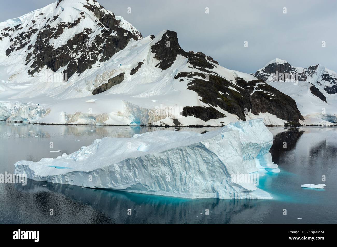 Eisberg in stillen Gewässern des Paradieshafens (Bucht) mit bryde-Insel dahinter. antarktische Halbinsel. antarktis Stockfoto