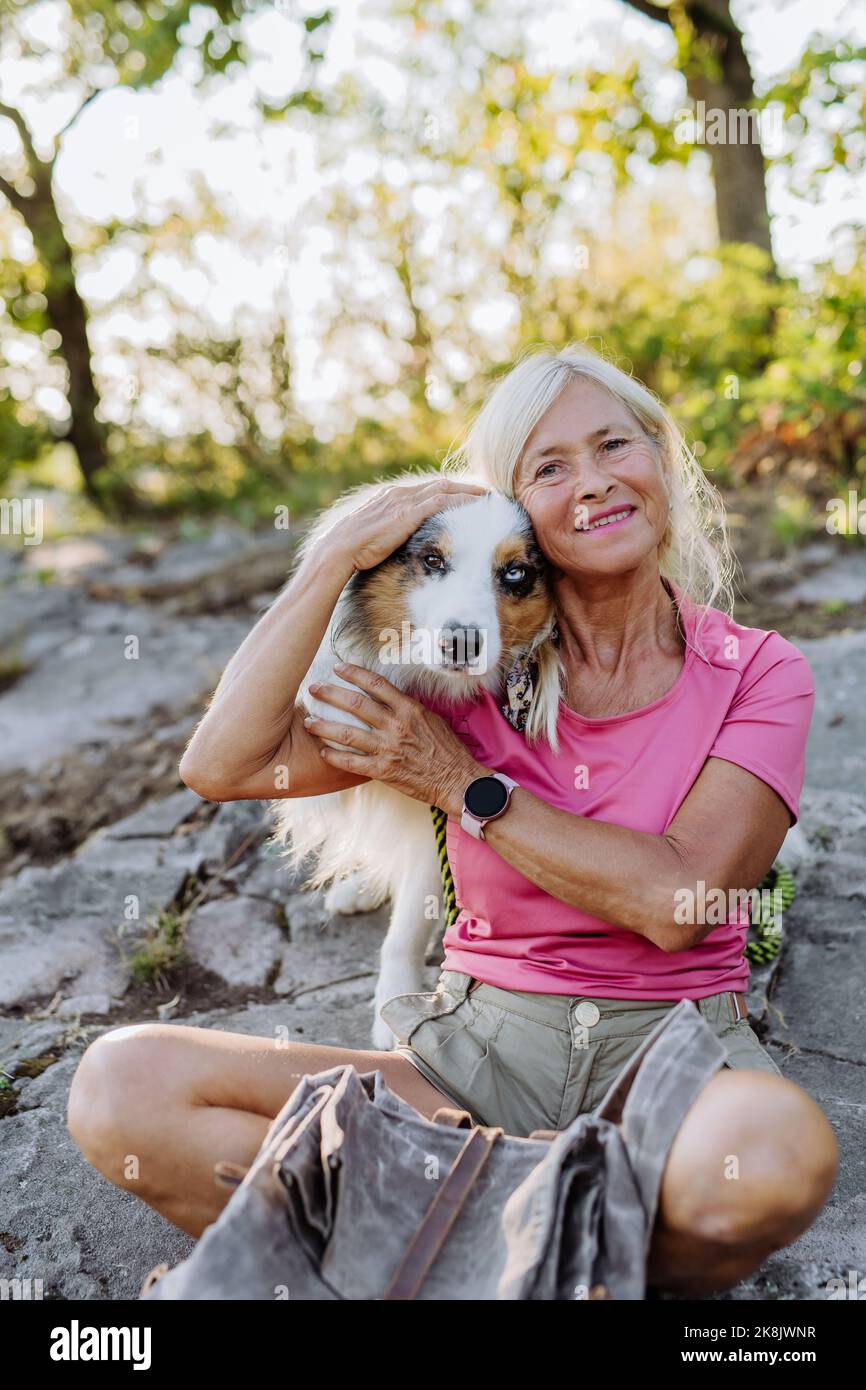 Porträt einer älteren Frau mit ihrem Hund im Wald. Stockfoto