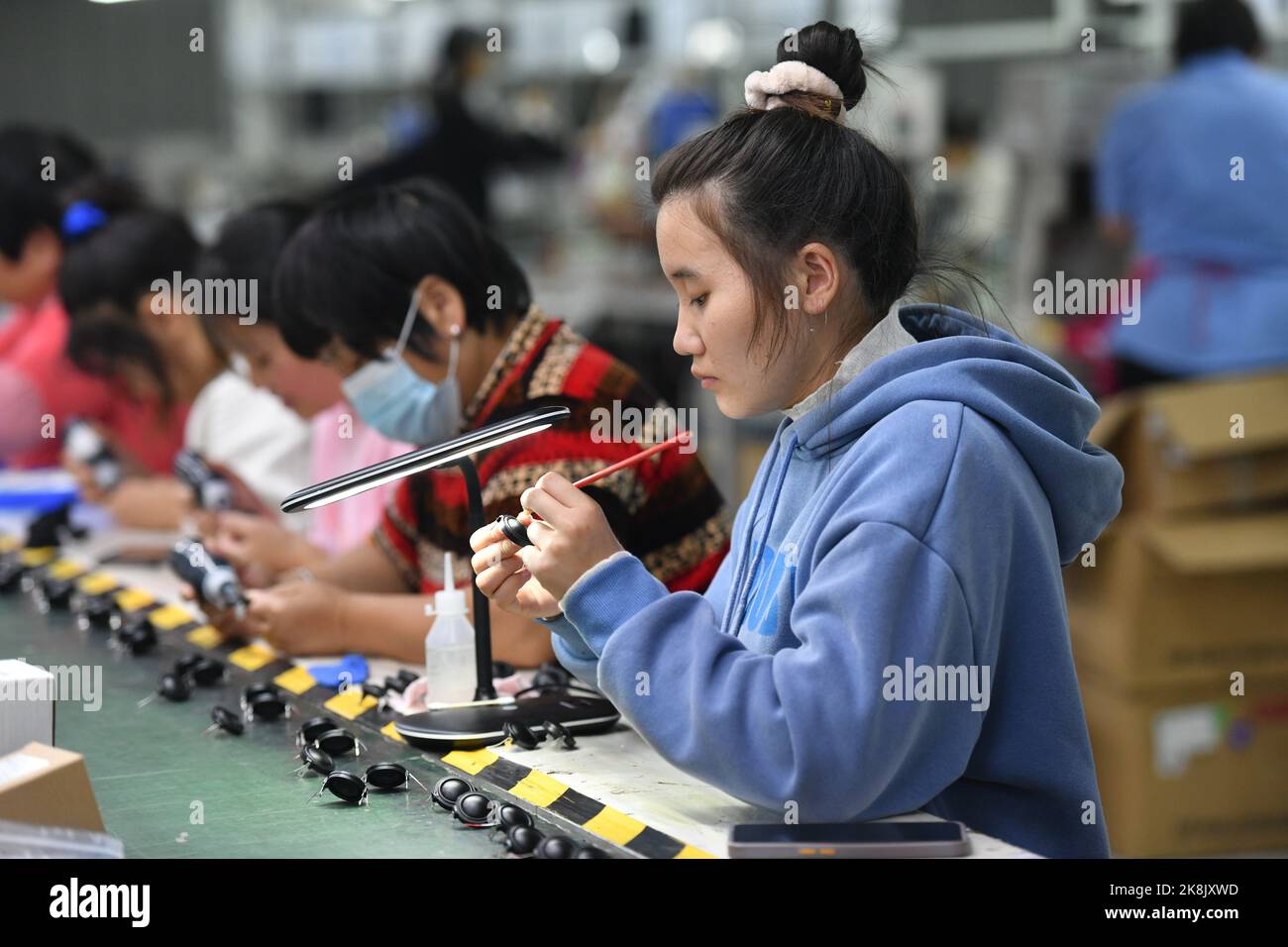 FUYANG, CHINA - 24. OKTOBER 2022 - Arbeiter arbeiten an der Lautsprecherproduktionslinie von Linquan Wuyang Electronics Co LTD in der Stadt Fuyang, Provinz Anhui, Stockfoto