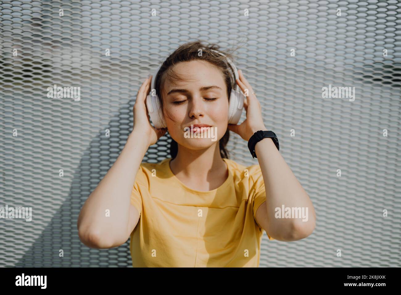 Porträt einer jungen Frau, die über Kopfhörer Musik hört. Stockfoto