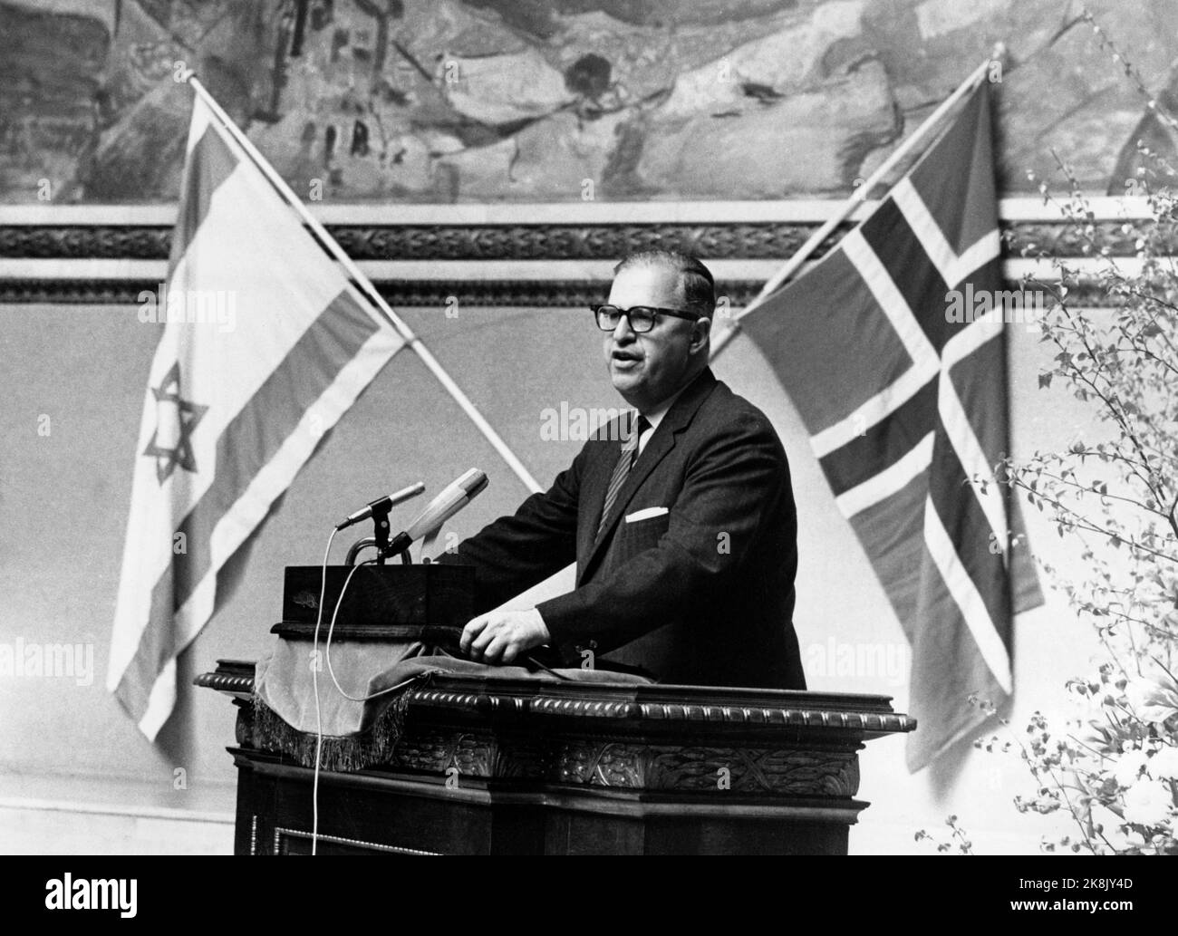 Oslo 19680506 Israels Außenminister ABBA Eban ist in Norwegen anlässlich der Feier des 20.. Jahrestages der Gründung des Staates Israel. Das Jubiläum wird mit einem Festtreffen im Auditorium der Universität gefeiert. Hier spricht Eban auf der Bühne im Auditorium. Norwegische und israelische Flaggen unter Munchs Gemälde im Hintergrund. Foto: Laurvik / NTB / NTB Stockfoto