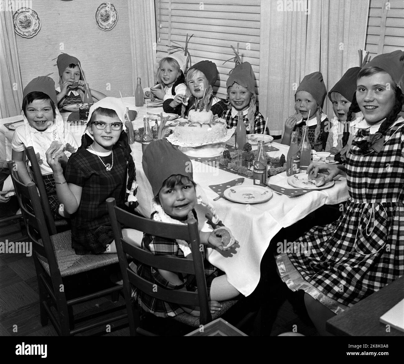 Oslo 19631127 Birthday Company / Children's Company / Birthday Company mit der Ole Moes Road Familie auf Nordstrand. Fröhliche Kinder am Kuchentisch, mit hausgemachten Papierhüten auf den Köpfen. Geburtstag Kind th. Foto: Erik Thorberg / NTB / NTB Stockfoto