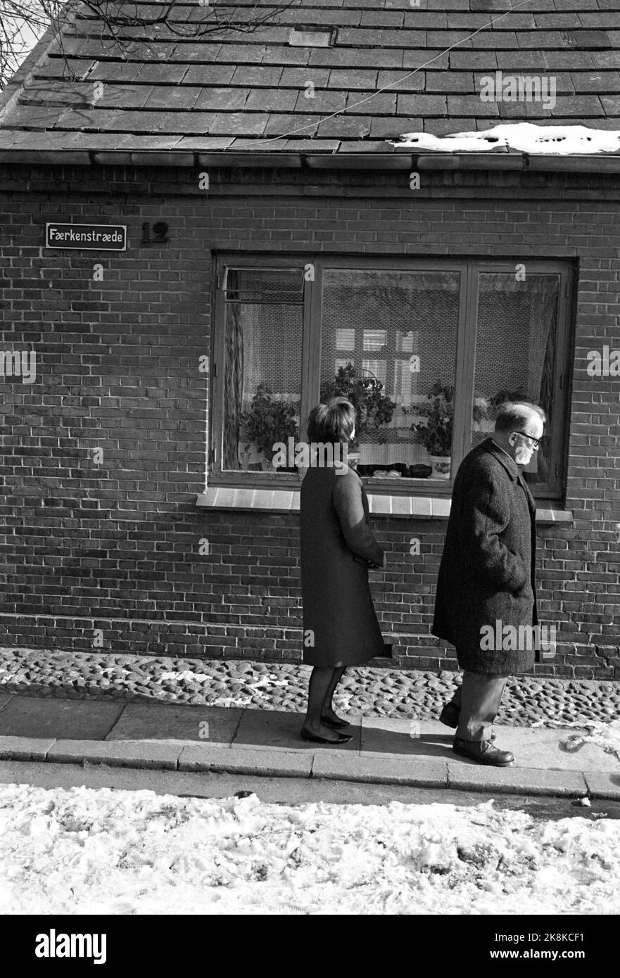 Nykøbing, Dänemark März 1965 - Autor Aksel Sandemose über alte Handlungen in seinem Geburtsort von Nykøbing, oder "Jante", wie er es in seinen Romanen nennt. Hier ist er mit seiner Frau Hanne Sandemose. Sie passieren das Haus, in dem Sandemose geboren wurde. Foto: Aage Storløkken / Aktuell / NTB Stockfoto