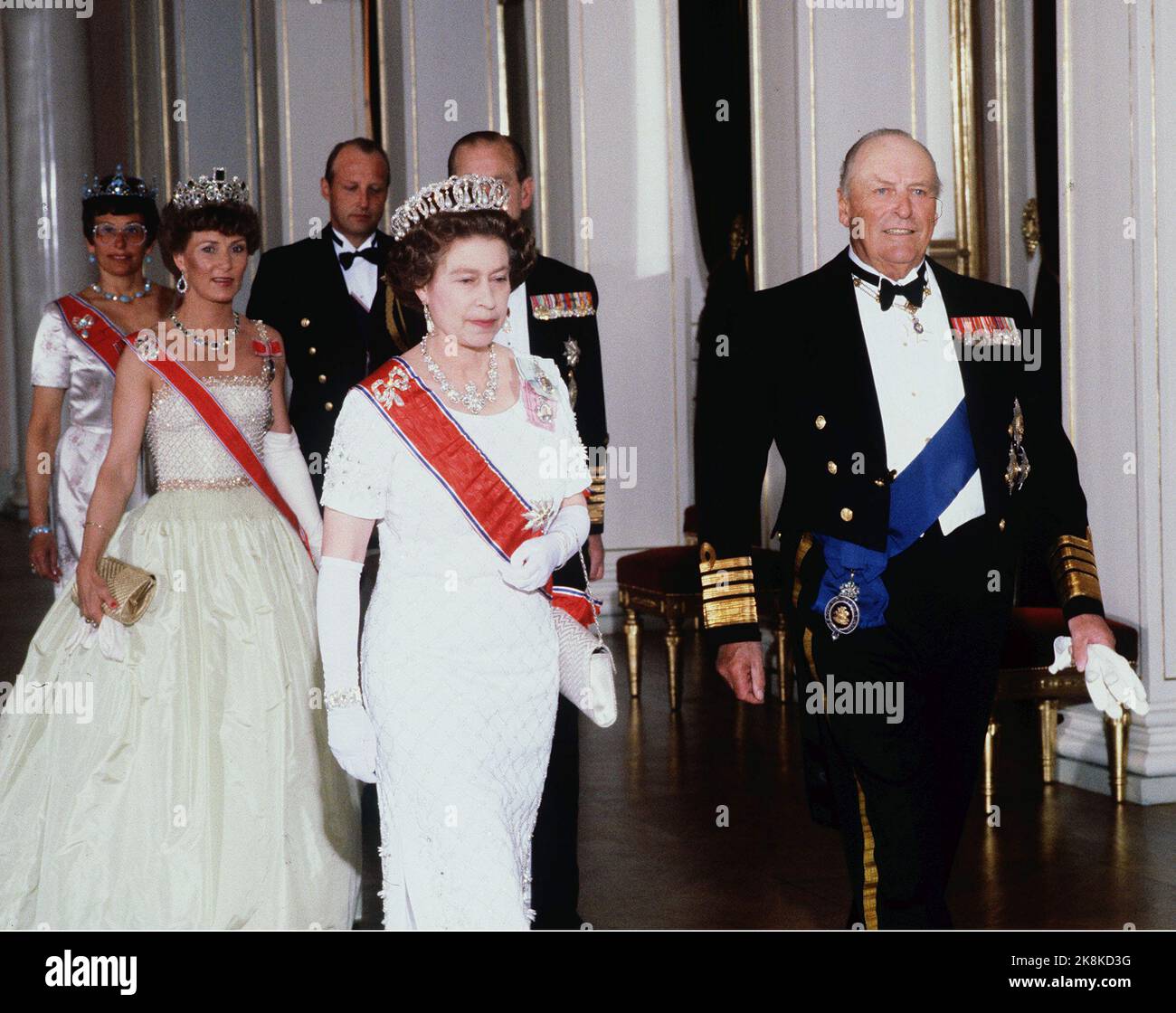 Oslo 19810505. Königin Elisabeth in Norwegen zu einem Staatsbesuch mit ihrem Mann. Galadiner im Schloss. Hier im Bild zuerst in der Serie von Königin Elizabeth und König Olav, hinter Kronprinzessin Sonja und Prinz Philip, Prinzessin Astred und Kronprinz Harald. Die Königin in weiß silbernem Kleid, weißer Tasche und langen weißen Handschuhen. Diadem. Sonja in cremegelbem Kleid. Foto: NTB-Archiv Bjørn Sigurdsøn BM dias Stockfoto