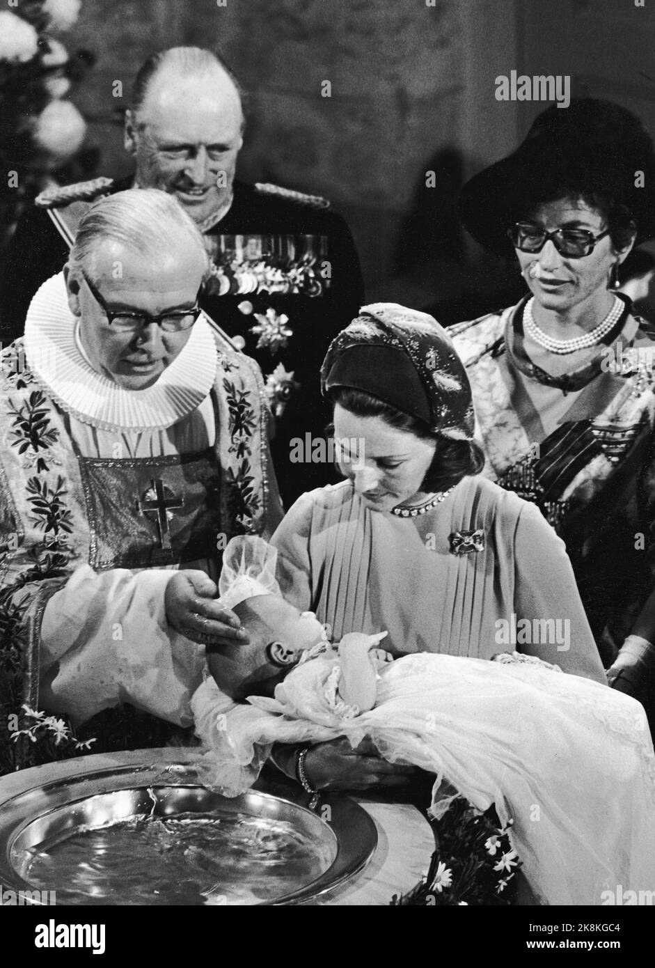 Oslo, das Schloss. 19730920. Prinz Haakon Magnus tauft auf dem Schloss. Kronprinzessin Sonja trägt ihren Sohn. Oslos Bischof Kaare Støylen führt das Taufritual durch - berührt die Stirn des Taufkindes mit Wasser aus dem Taufbecken. Im Hintergrund König Olav und Prinzessin Aestr Mrs. Ferner. Foto: NTB-Archiv / NTB Stockfoto