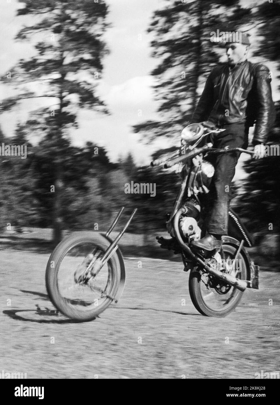 Alunda, Schweden 1954 als Motorradfahrer in Alunda in Schweden einen kleinen privaten Wettbewerb abhielten, sollte einer der kubischen Rucke das machen, was die Schweden als "Kavallerie-Start" bezeichnen. Er hat auch das Motorrad wirklich gut zu stehlen, aber dann ging es nicht so gut, weil das Vorderrad die Maschine verließ und einen Spaziergang alleine machte. Ein Mann mit Kamera, Torsten Malmberg, bekam ein Bild, das viel besser wurde, als er gedacht hatte, und überall in Schweden bekamen die Menschen ein gutes Grinsen. Seltsam mit dieser Freude! Foto; Torsten Malmberg / Aktuell / NTB physische LOC. Aktuelle Nr. 25- 1954 Streif-Leuchten Stockfoto