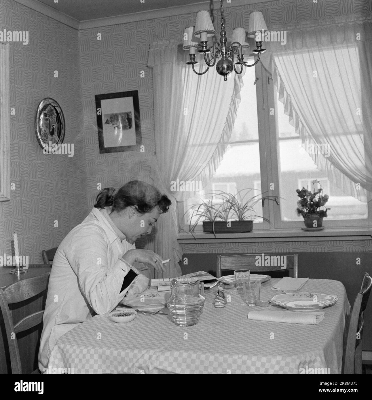 Oslo 1956. Eine Frau sitzt still und liest die Zeitung, während sie eine Zigarette raucht. Eine Hausfrau atmet nach der Hausarbeit. Foto: Sverre A. Børretzen / Aktuell / NTB Stockfoto