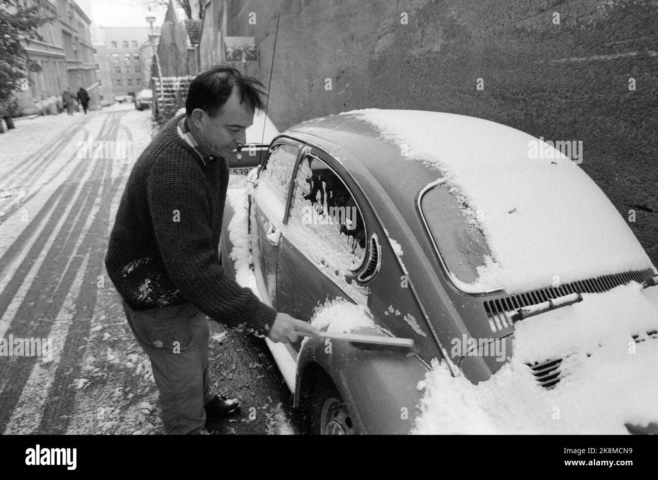 Oslo 19921016: Der erste Schneefall in der Hauptstadt im Winter 1992. Hier von Dovregata bei St. Hanshaugen. Der Mensch kostet Schnee aus seiner heruntergekommenen „Volkswagen-Blase“. Foto: Aleksander Nordahl / NTB / NTB Stockfoto