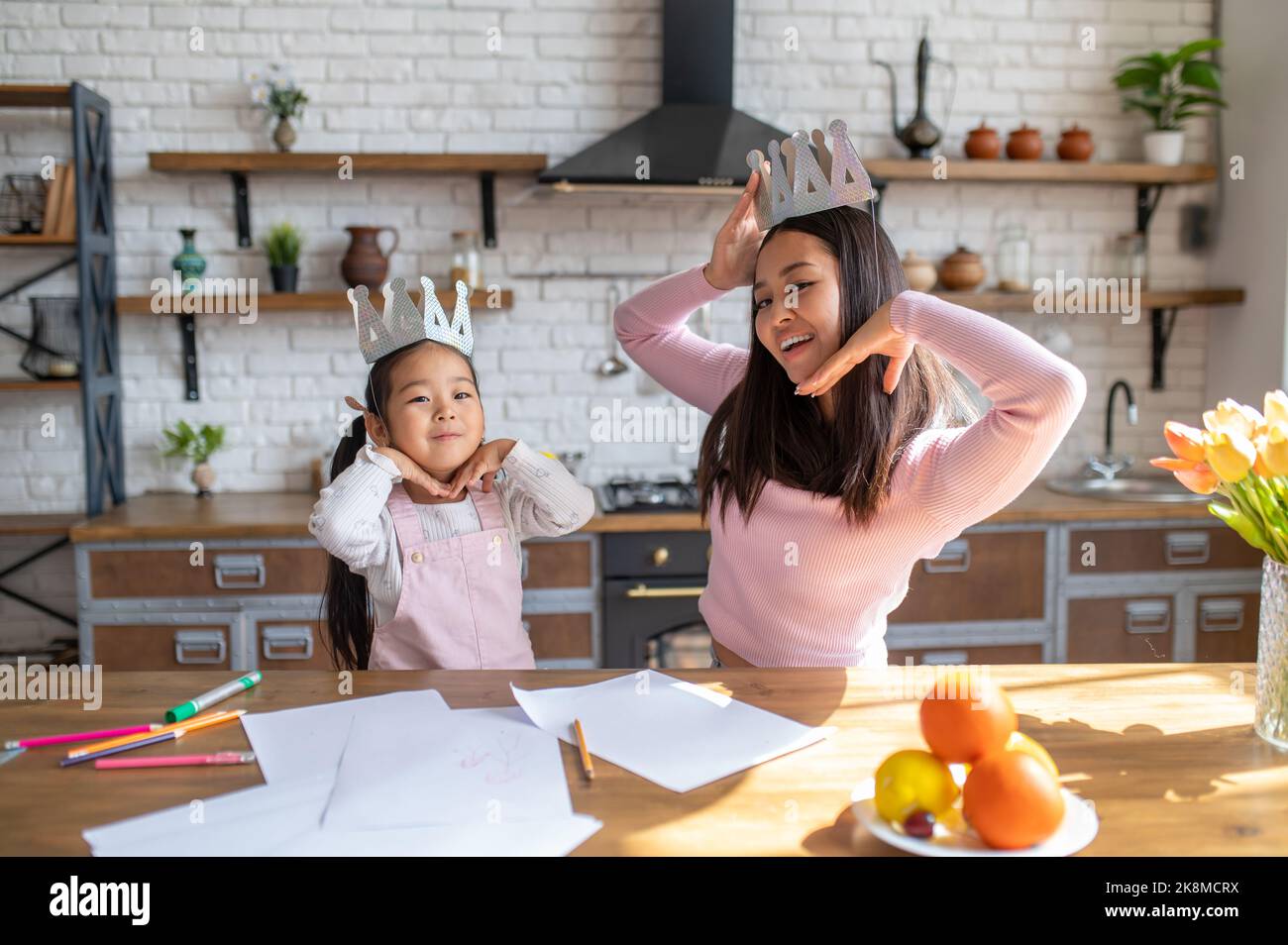 Mutter und Tochter posieren für die Kamera in der Küche Stockfoto