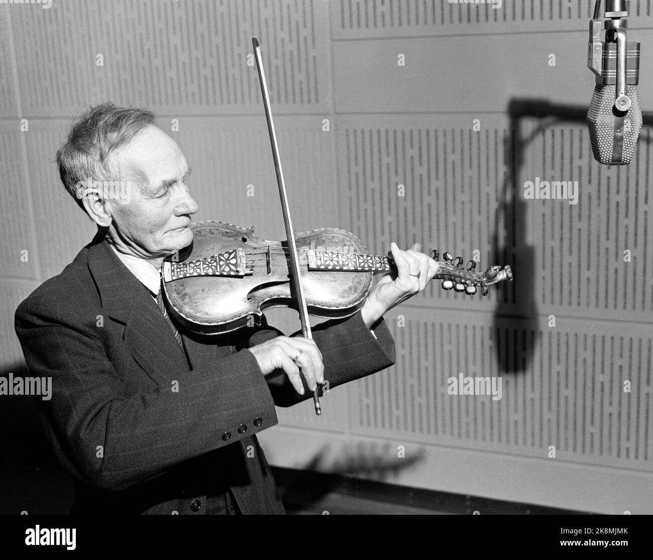 Oslo 19510319 Norwegische Volksmusik wird in NRK aufgenommen. Hier der Geiger Olav Moe (1872-1968), der im Studio die härtende Geige vor dem Mikrofon spielt, für das Programm Volksmusik halb. Foto: NTB / NTB Stockfoto