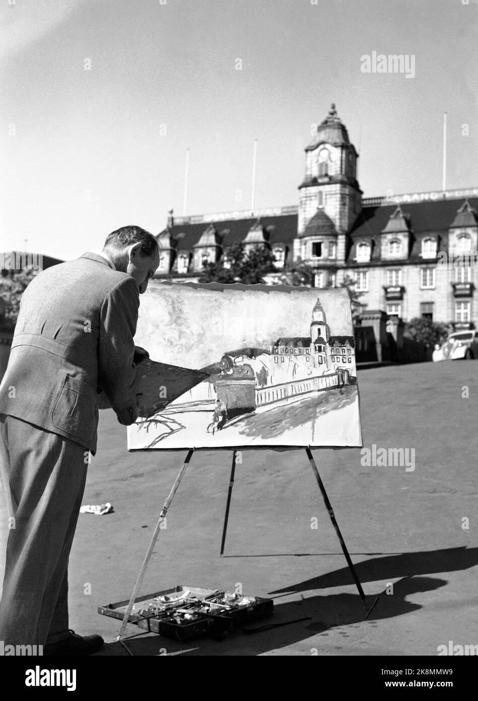 Oslo 19490529 Sommerbild aus der Hauptstadt. Ein Kunstmaler hat mit seiner Staffelei in Løvebakken im Storting Stellung beziehen können. Hier verewigt er das Grand Hotel und einen der Löwen in Løvebakken auf seinem Gemälde. Foto: NTB / NTB Stockfoto