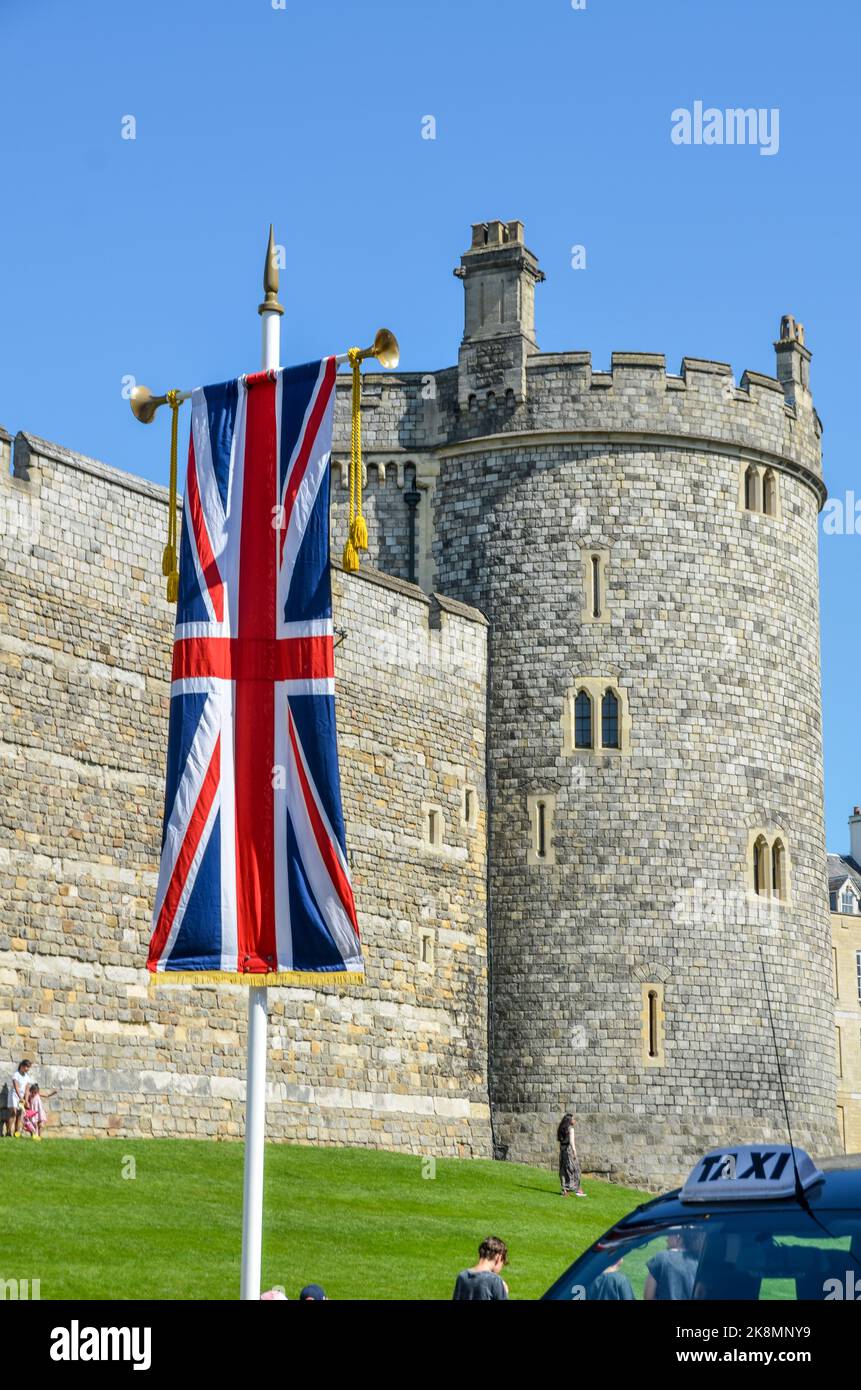 Eine vertikale Aufnahme der britischen Flagge mit dem Curfew Tower im Hintergrund. Stockfoto