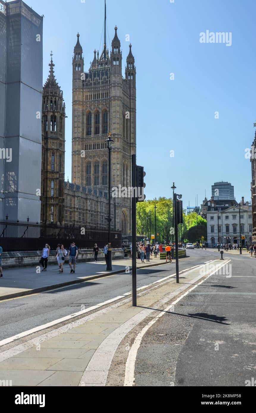 Eine vertikale Aufnahme der Straßen von London, Großbritannien, mit Menschen und dem Victoria Tower im Hintergrund. Stockfoto