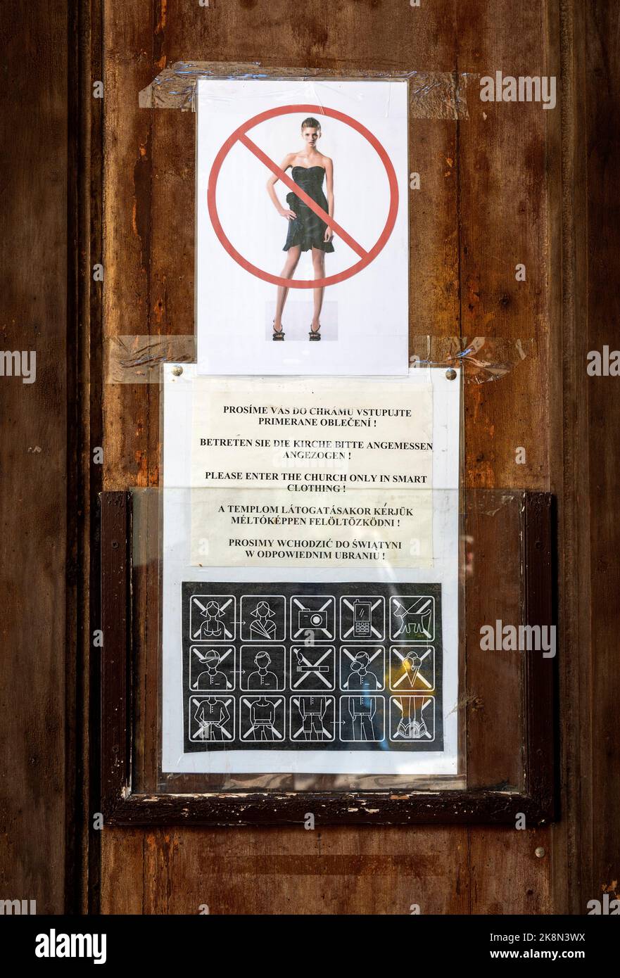 Nachfrage nach passender Kleidung mit Symbolen und Foto an einer Kirchentür in der Slowakei Stockfoto