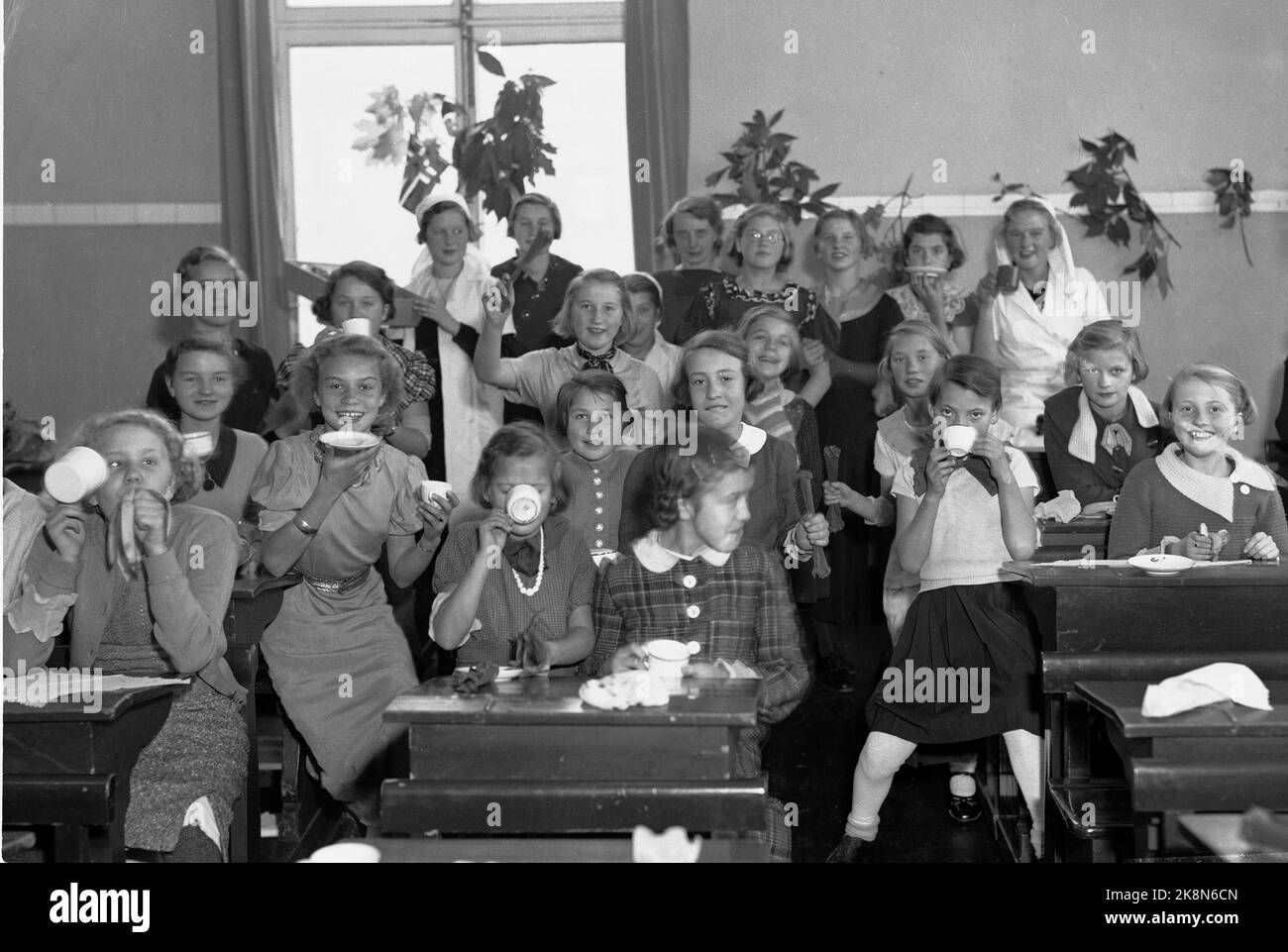 Oslo September 1936. 50.-jähriges Jubiläum der Schule in Bjølsen. Fröhliche Mädchen trinken Kakao und essen Bananen anlässlich des Jubiläums. Einige der Mädchen trinken Kakao aus der Schüssel. Foto: NTB / NTB (Schule wurde am 12. Oktober 1886 genutzt) Stockfoto