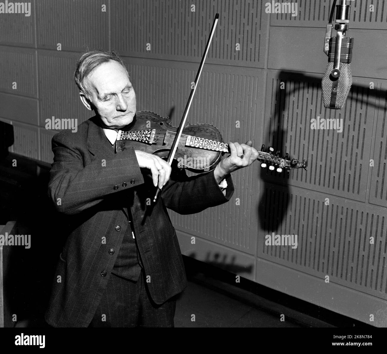 Oslo 19510319 Norwegische Volksmusik wird in NRK aufgenommen. Hier der Geiger Olav Moe (1872-1968), der im Studio die härtende Geige vor dem Mikrofon spielt, für das Programm Volksmusik halb. Foto: NTB / NTB Stockfoto
