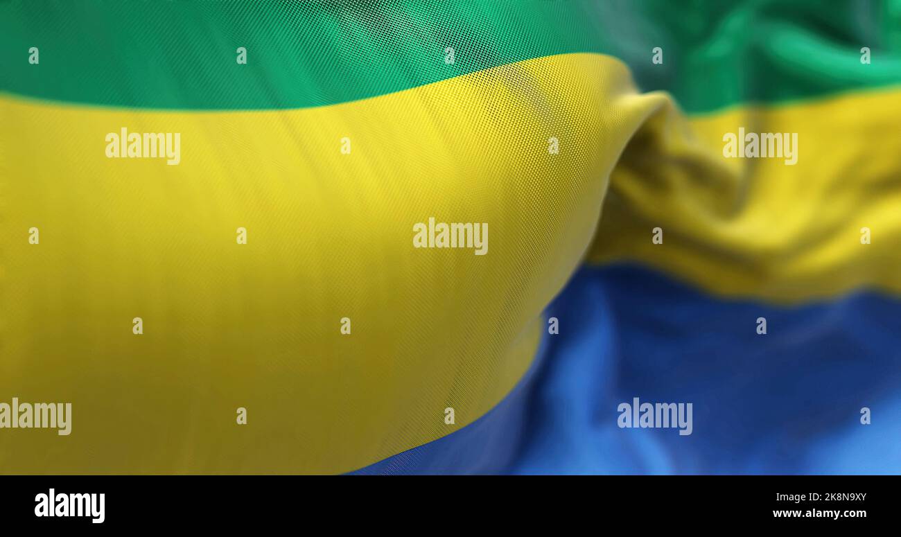 Nahaufnahme der Gabun-Nationalflagge, die im Wind winkt. Die Republik Gabun ist ein zentralafrikanisches Land. Texturierter Hintergrund aus Stoff. Selektiv Stockfoto