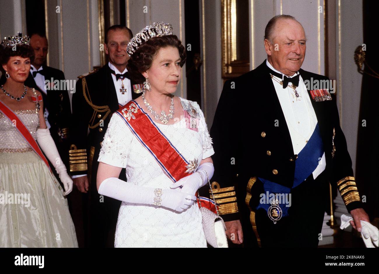 Oslo 19810505. Königin Elizabeth in Norwegen bei einem Staatsbesuch mit ihrem Mann Prinz Philip. Galadiner im Schloss. Hier im Bild Königin Elizabeth und König Olav, hinter Kronprinzessin Sonja und Prinz Philip. Die Königin in weiß silbernem Kleid, weißer Tasche und langen weißen Handschuhen. Foto: NTB-Archiv Bjørn Sigurdsøn Stockfoto