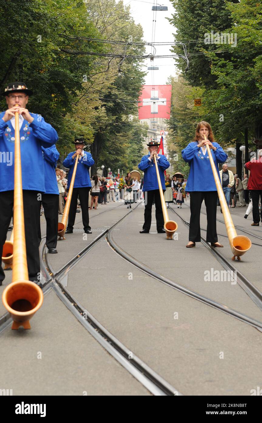 Alphornbläser auf der Bahnhofstrasse am Nationalfeiertag. Alphornmusiker spielen am Schweizer Nationalfeiertag in der Zürichs Bahnhofstraße Stockfoto