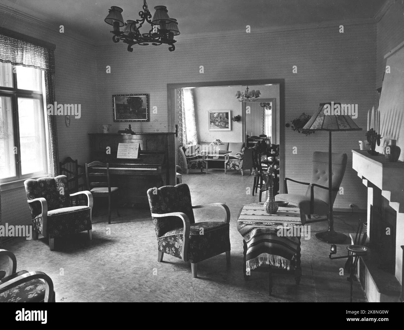 Oslo 1950 Interieurs aus einem Wohnzimmer in einem modernen Zuhause. Army Stühle mit Armlehnen aus Holz. Klavier, Stahllampe, Deckenlampe, Kamin. Foto: NTBSCANPIX Stockfoto