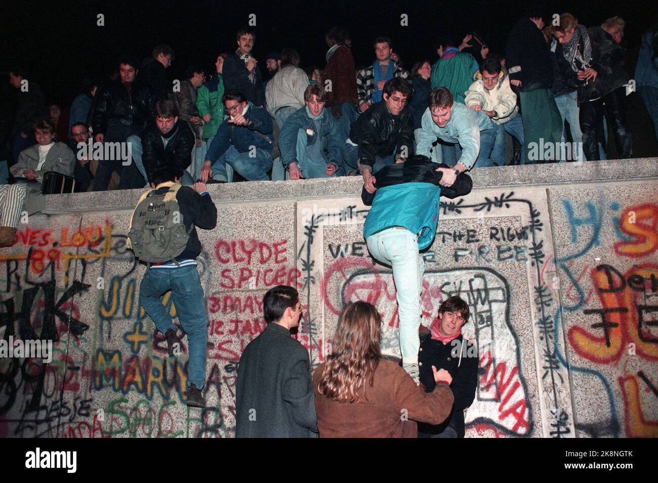 19891110 Fall der Berliner Mauer: Tausende Menschen krochen am Freitagabend auf die Mauer am Brandenburger Tor in Vest-Berlin. .. Foto von Jugendlichen, die die Wand hochklettern. Foto: Jørn H. Moen / NTB Stockfoto