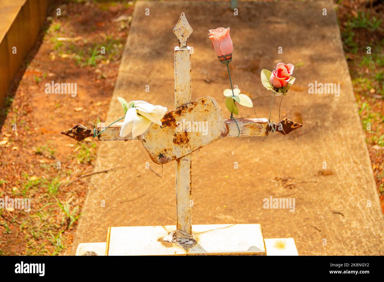 Aparecida de Goiânia, Goias, Brasilien – 23. Oktober 2022: Ein Kreuz mit Blumen über einem Betongrab auf dem Friedhof. Stockfoto