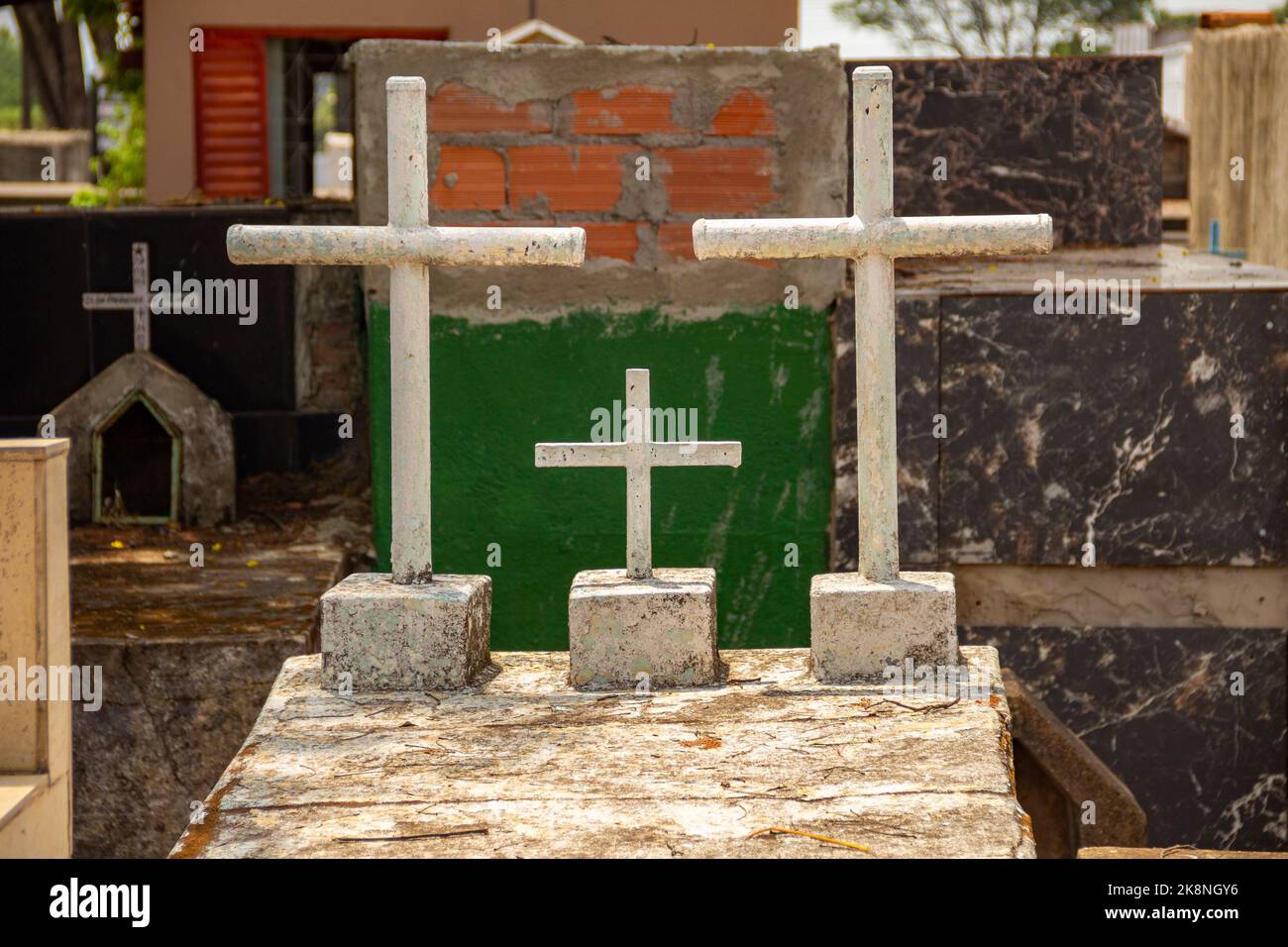 Aparecida de Goiânia, Goias, Brasilien – 23. Oktober 2022: Einige Kreuze über Gräbern mit verschwommenem Friedhof im Hintergrund. Stockfoto