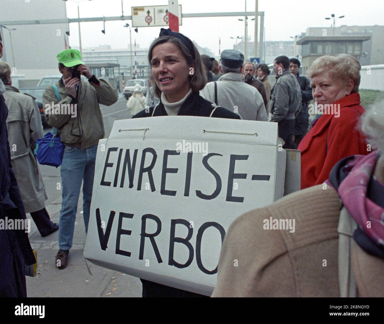Berlin, Deutschland 19891113: Fall der Berliner Mauer: Die Mauer zwischen Ost- und Westdeutschland öffnet sich in Berlin. Die 51-jährige Helga Liersch demonstrierte am Grenzübergang Checkpoint Charlie, weil sie nicht in die DDR einreisen und das Grab ihrer Großeltern besuchen durfte. Helga Liersch mit einem Plakat mit dem Text EinsteReverbot. Foto: Jørn H. Moen, NTB Stockfoto
