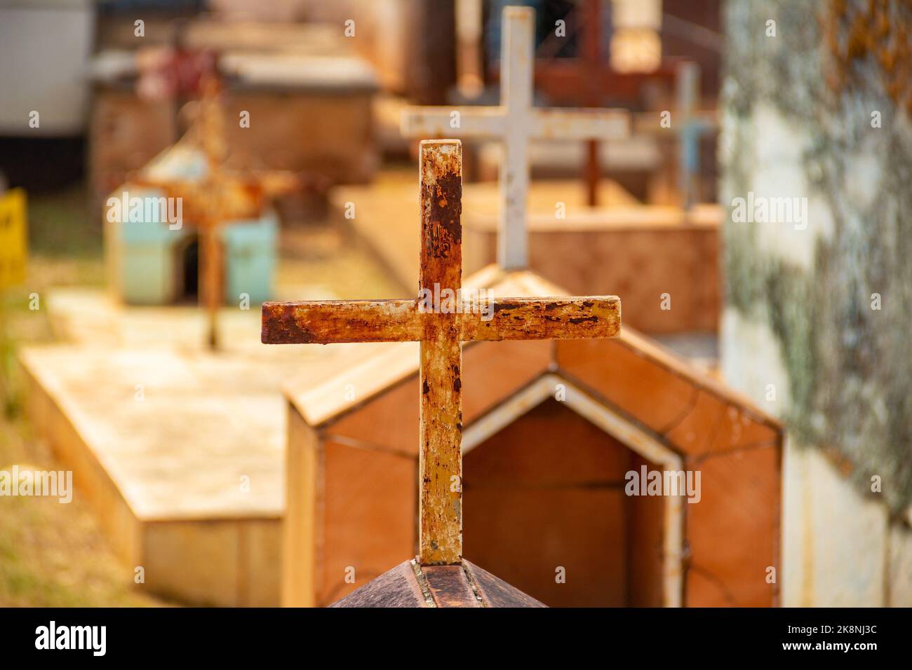 Aparecida de Goiânia, Goias, Brasilien – 23. Oktober 2022: Ein einfaches Kreuz, über einem Grab mit dem Friedhof im Hintergrund verschwommen. Stockfoto