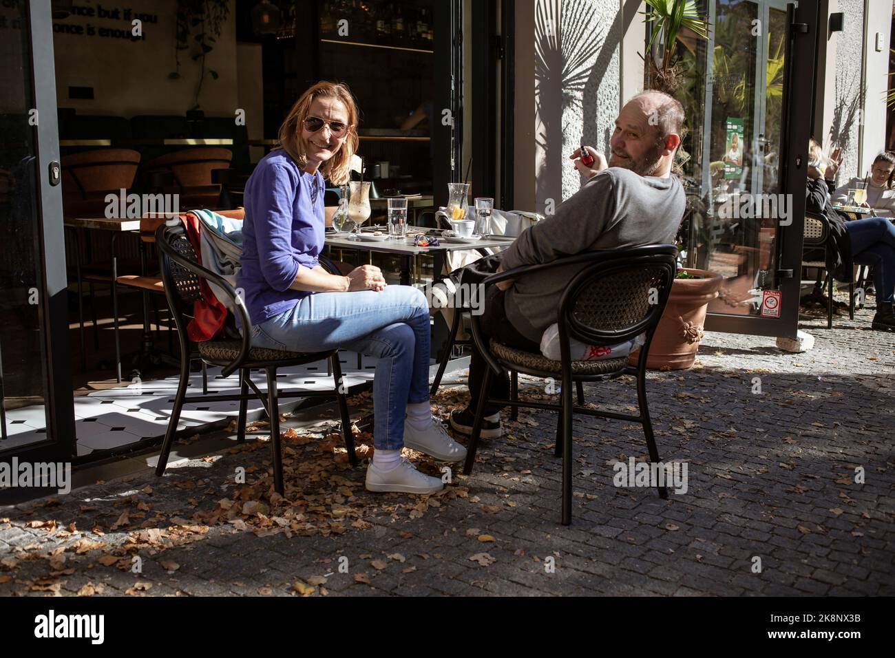 Belgrad, Serbien, 18. Okt 2022: Ein Paar mit guter Laune, das in einem der Zemun Coffee Shops Kaffee getrunken hat Stockfoto
